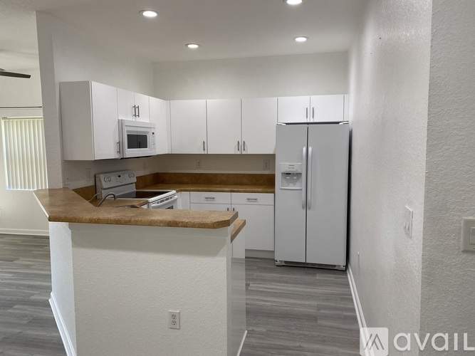 A kitchen with white cabinets and a wooden countertop.