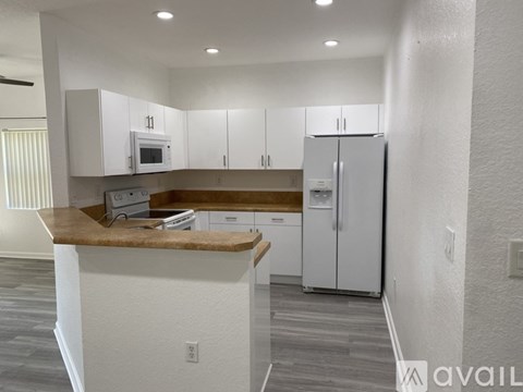 A kitchen with white cabinets and a wooden countertop.