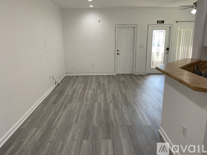 A room with a wooden floor and a white door.