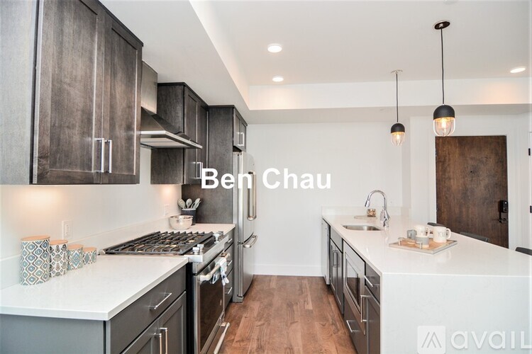 A modern kitchen with dark wood cabinets and white countertops.