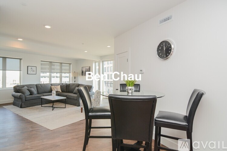 A living room with a couch, chairs, and a dining table.
