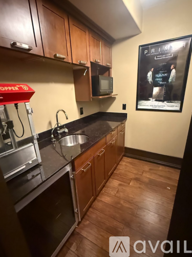 A kitchen with wooden cabinets and a poster of a movie.