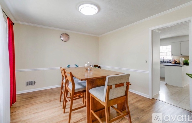 A dining room with a wooden table and chairs.