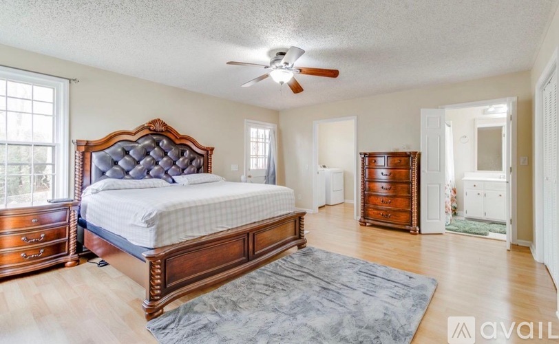 A bedroom with a large bed, dresser, and mirror.