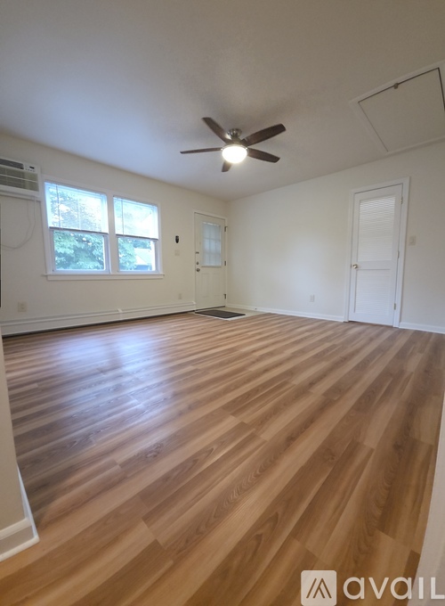 A room with wooden flooring and a ceiling fan.