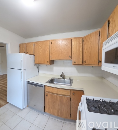 A kitchen with wooden cabinets and white appliances.