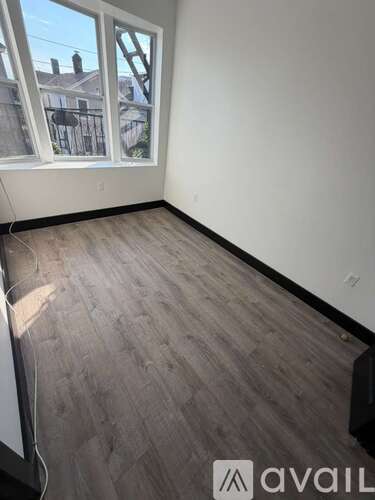 A room with a window and wooden flooring.