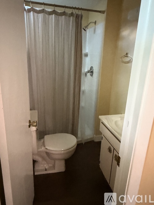 A small bathroom with a toilet, sink and shower.