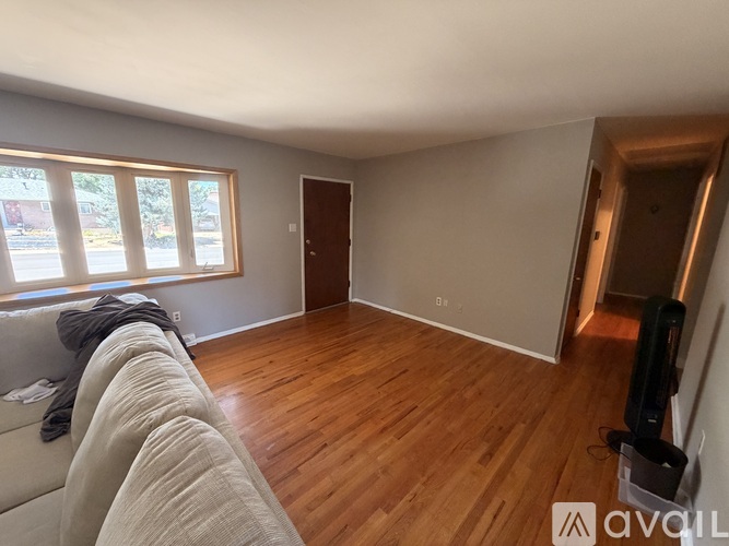 A living room with a couch and a wooden floor.