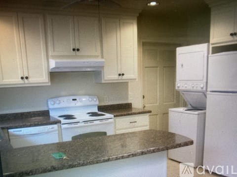 A kitchen with white appliances and cabinets.