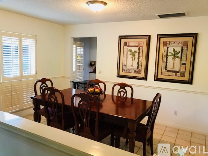 A dining room with a wooden table and chairs.