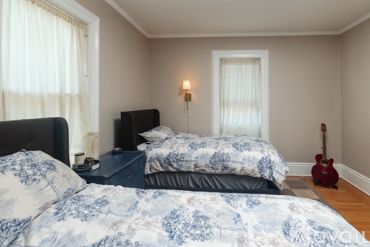 A bedroom with two beds and a guitar.