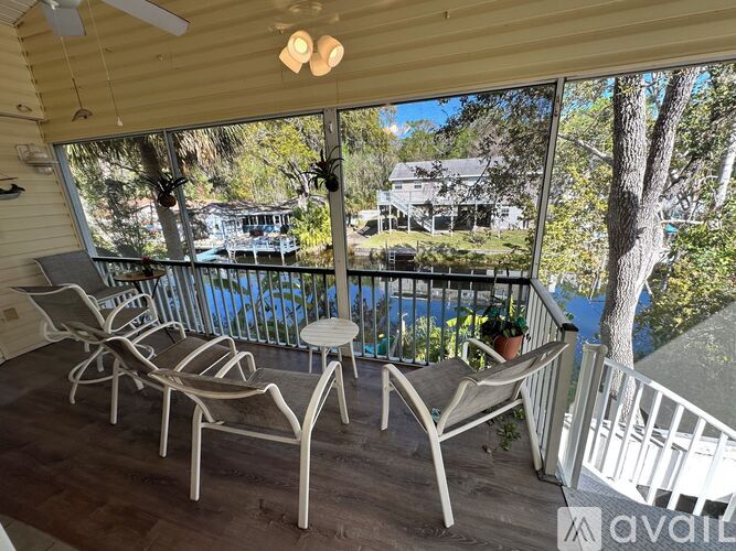 A balcony with chairs and a table overlooking a pool.