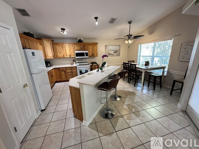 A kitchen with white appliances and wooden cabinets.