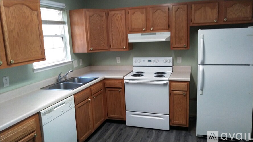 A kitchen with wooden cabinets and white appliances.