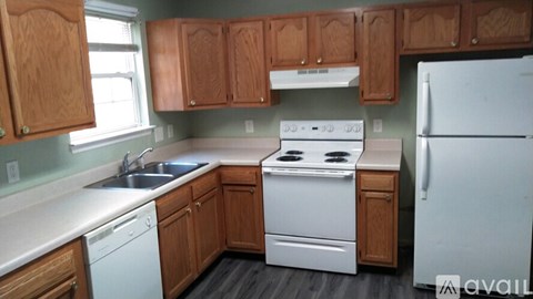 A kitchen with wooden cabinets and white appliances.