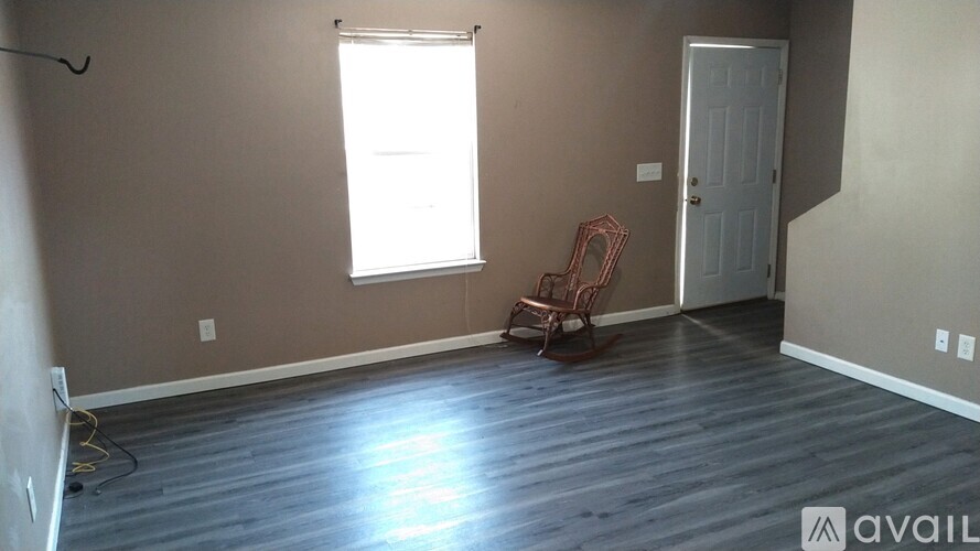 A room with a wooden floor and a white door.