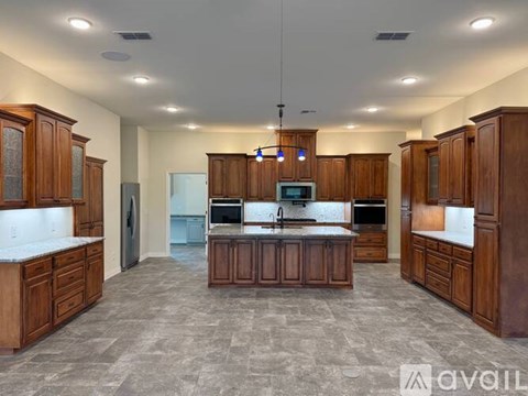 A spacious kitchen with wooden cabinets and a central island.