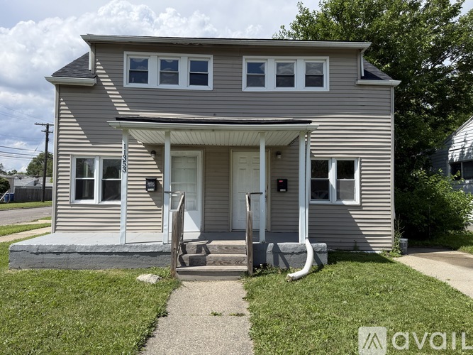 A two-story house with a front porch and a white door.