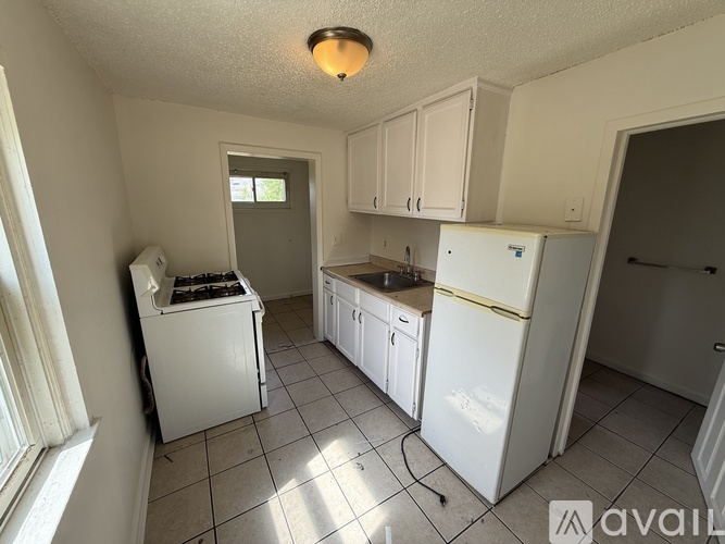 A kitchen with white appliances and cabinets.