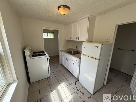 A kitchen with white appliances and cabinets.