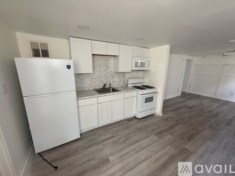 A kitchen with white appliances and cabinets.