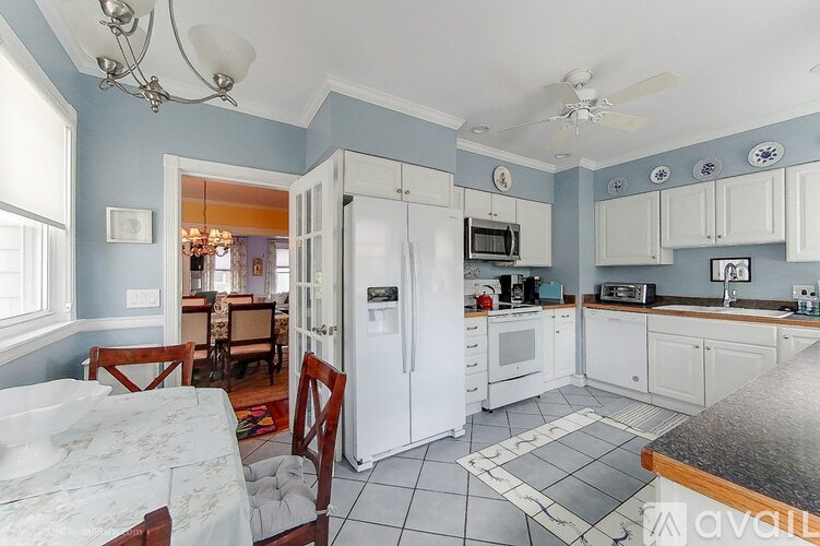 A kitchen with white appliances and a table with chairs.