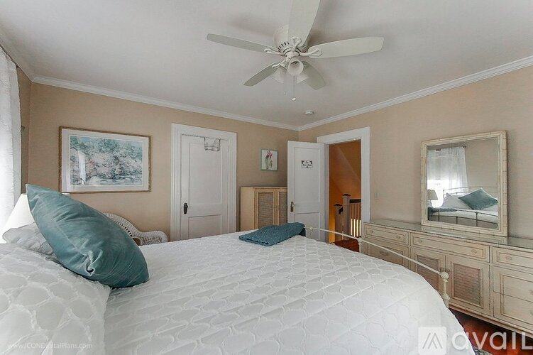 A bedroom with a large bed and a ceiling fan.