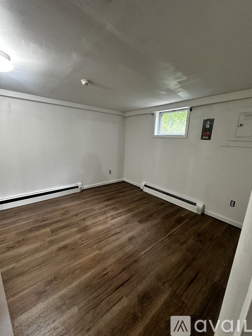 A room with wooden flooring and white walls.