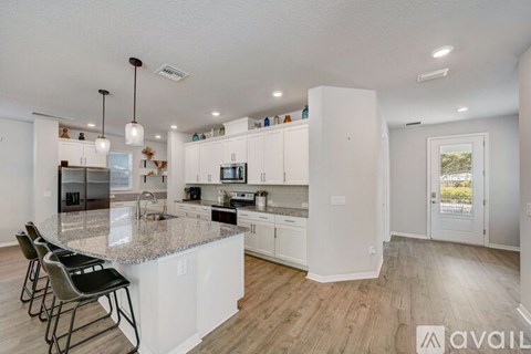 A kitchen with white cabinets and a granite countertop.
