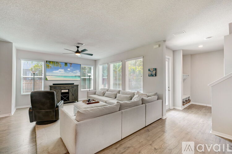 A living room with a white couch and a ceiling fan.