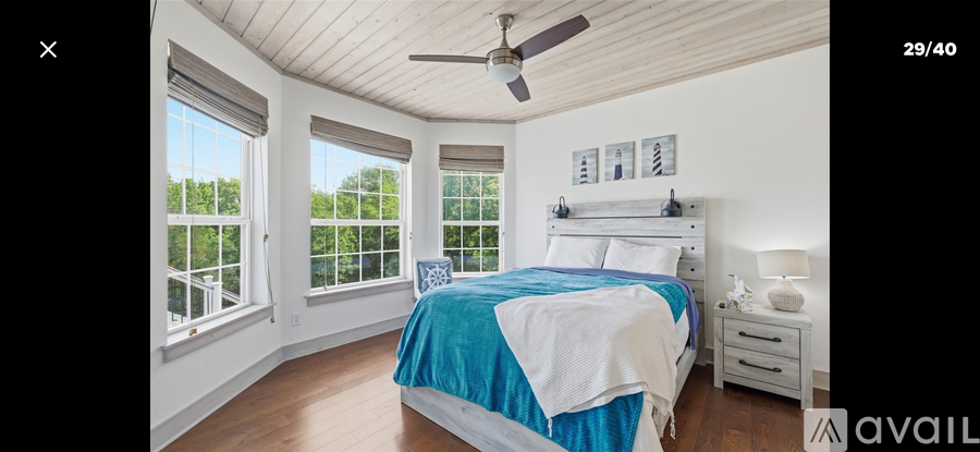 A bedroom with a bed, nightstand, and window.