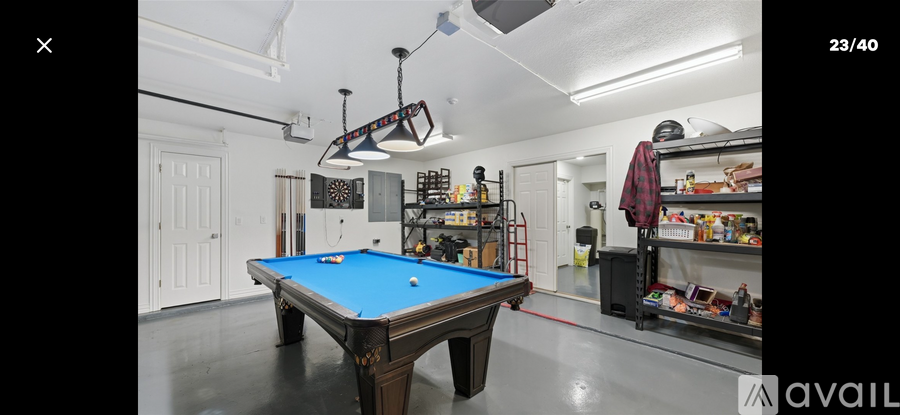 A room with a pool table and a shelf with items on it.