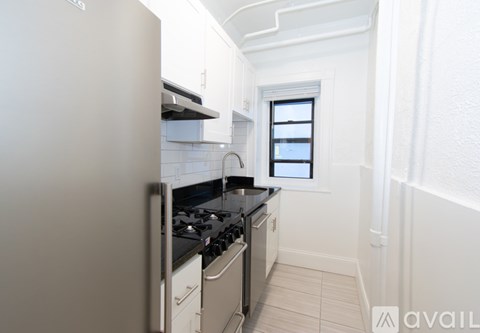 A small kitchen with white appliances and a window.