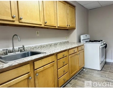 A kitchen with wooden cabinets and a granite countertop.