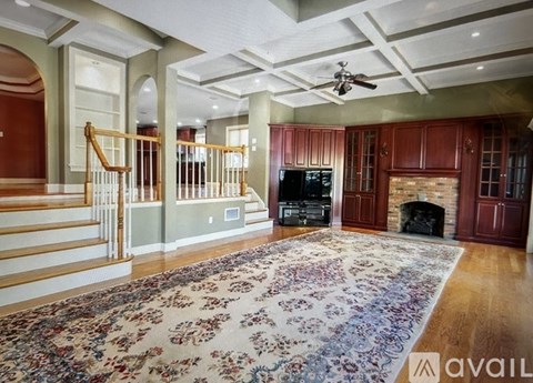 A living room with a rug on the floor and a fireplace.