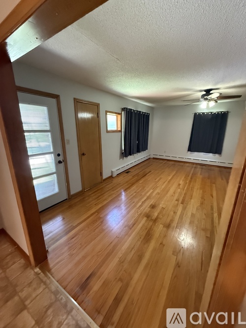 A room with wooden floors and a ceiling fan.