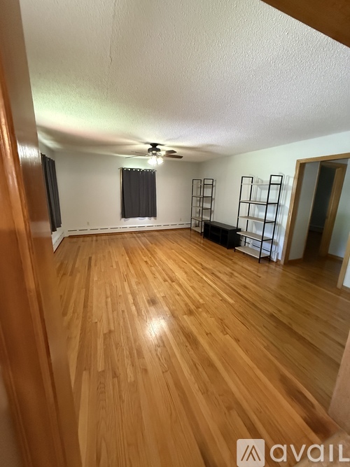 A room with wooden flooring and a ceiling fan.