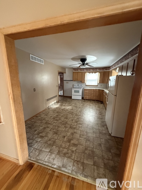 A kitchen with a fan and a refrigerator.