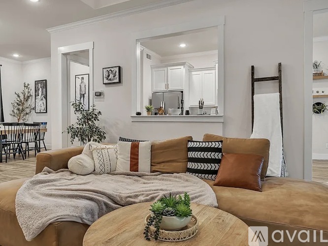 A living room with a brown couch and a wooden coffee table.