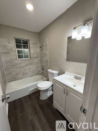 A bathroom with a toilet, sink, and tub.