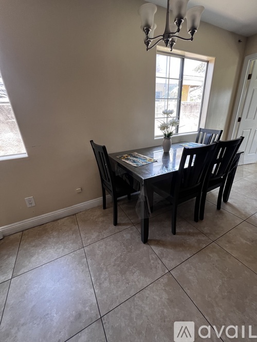 A dining room with a table and chairs.