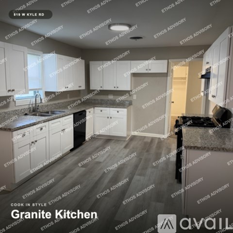 A granite kitchen with white cabinets and a black countertop.