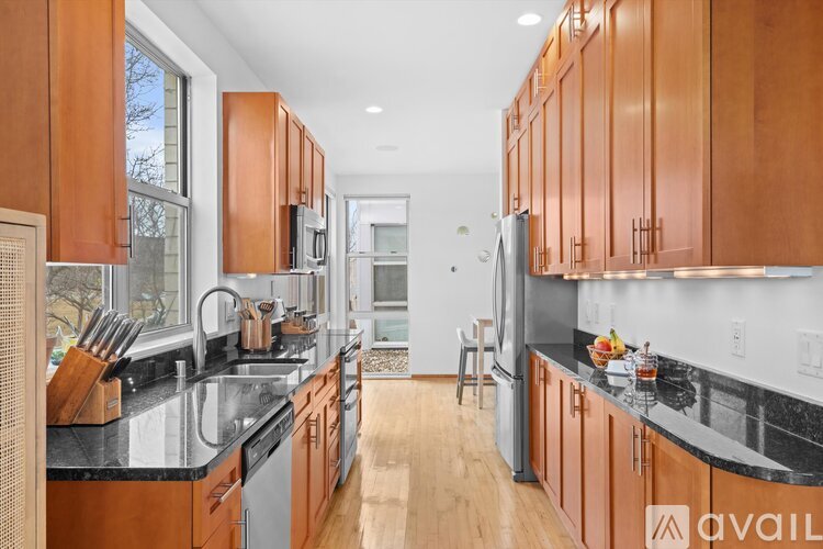 A kitchen with wooden cabinets and black countertops.
