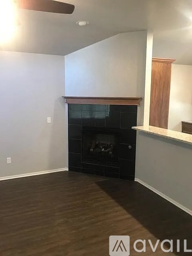 A living room with a fireplace and wood flooring.