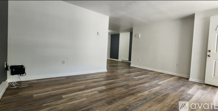 A room with wooden flooring and white walls.