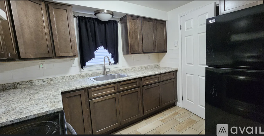 A kitchen with brown cabinets and a black oven.