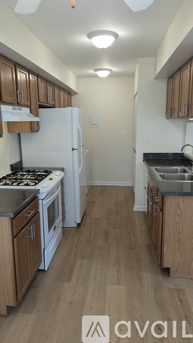 A kitchen with wooden cabinets and a white refrigerator.