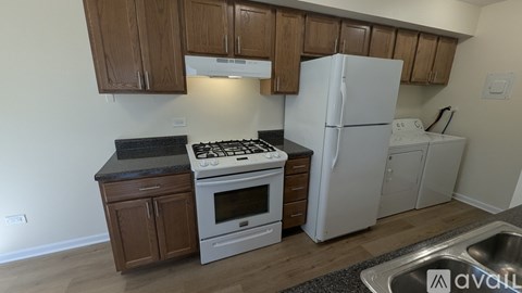 A kitchen with a white fridge, stove, and oven.