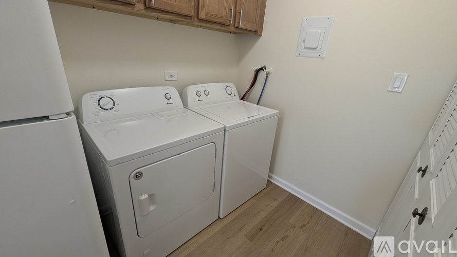 A white washing machine and dryer in a small laundry room.